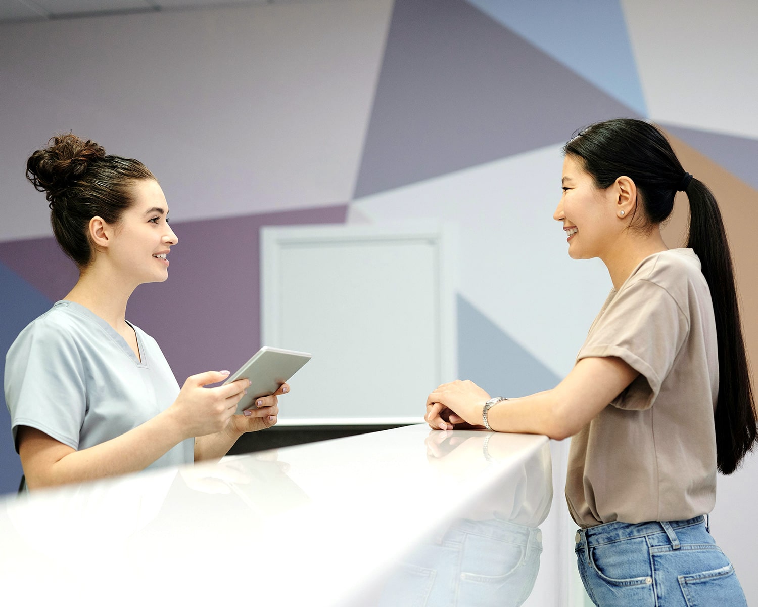Receptionist greeting a patient at the front desk
