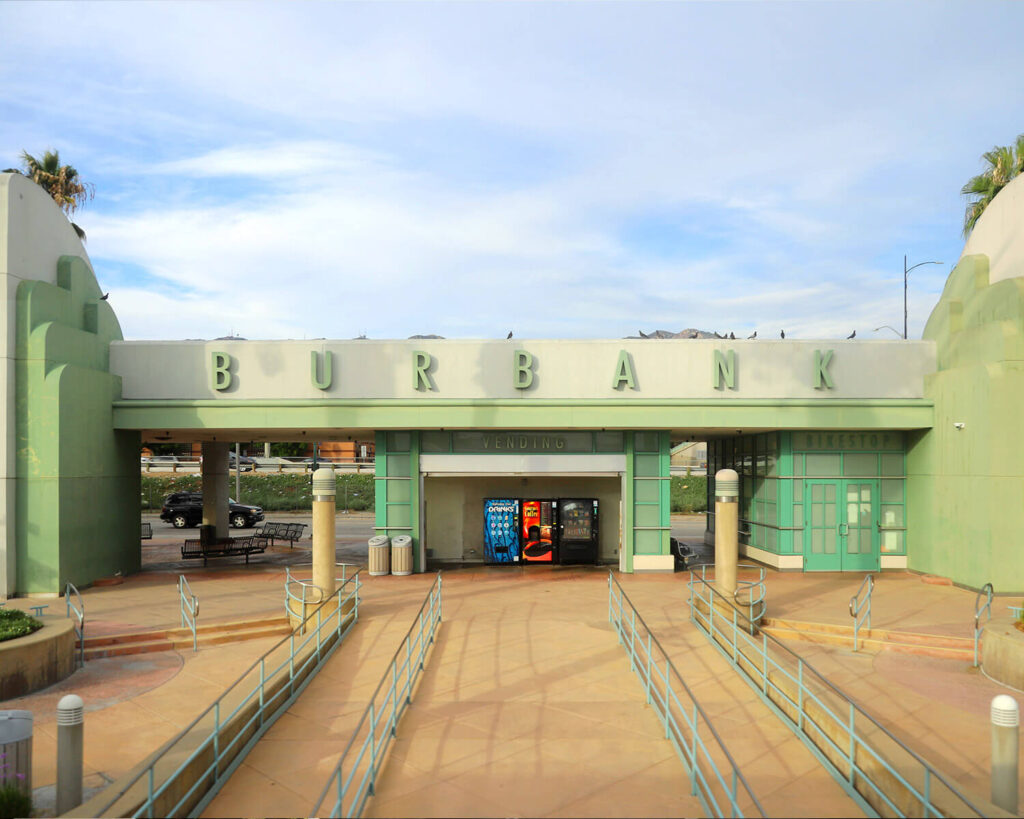 Burbank CA train station entrance with art deco design, large BURBANK sign, and vending area