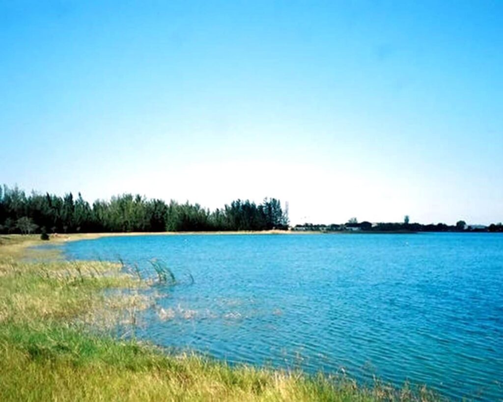 Scenic lake view at Amelia Earhart Park in Hialeah, Florida with grassy shore and blue water