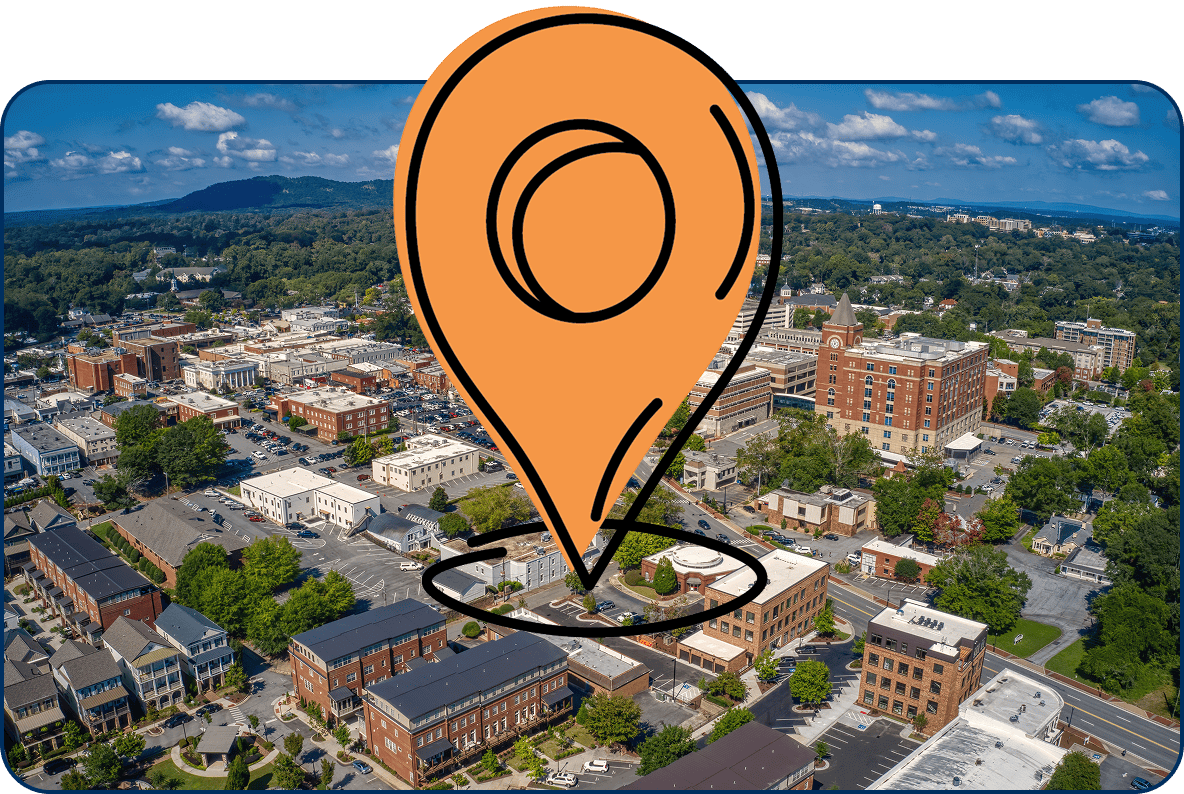 Large location pin icon over an aerial view of Marietta, Georgia with buildings, and trees