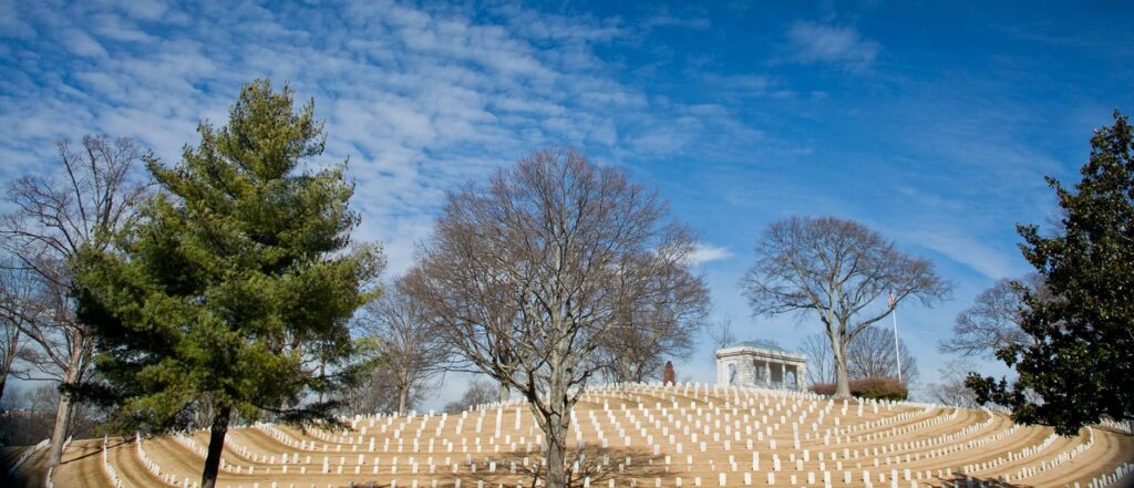 Marietta National Cemetery GA with rows of white headstones, trees, and historic memorial