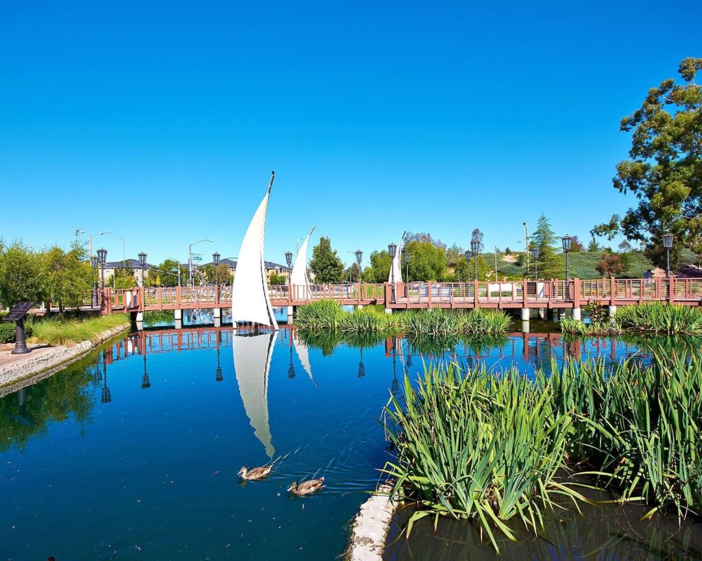 Bridgeport Lake in Santa Clarita CA with sail-shaped lighthouse, wooden bridge, and ducks on the water