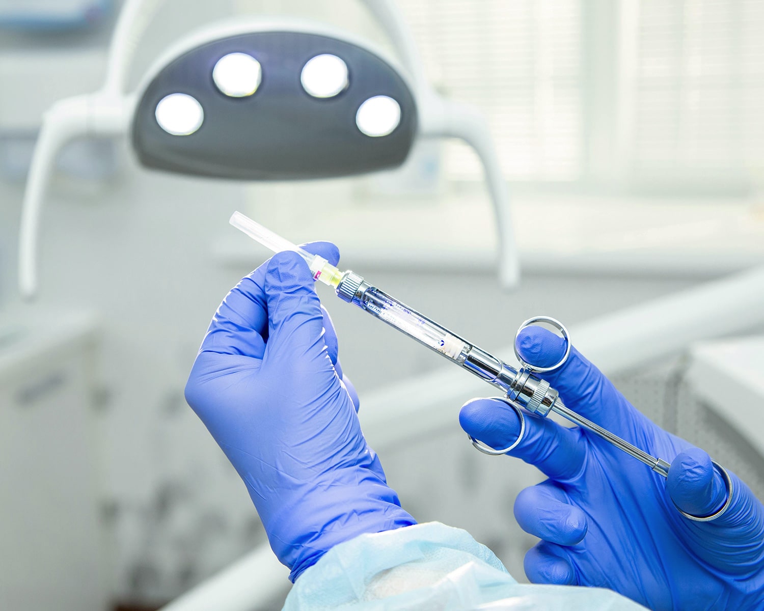 Dentist wearing gloves holding syringe with anesthetic for sedation