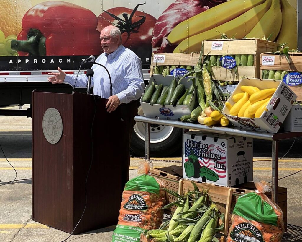 Speaker at Atlanta State Farmers Market in Stockbridge, Georgia with crates of fresh produce