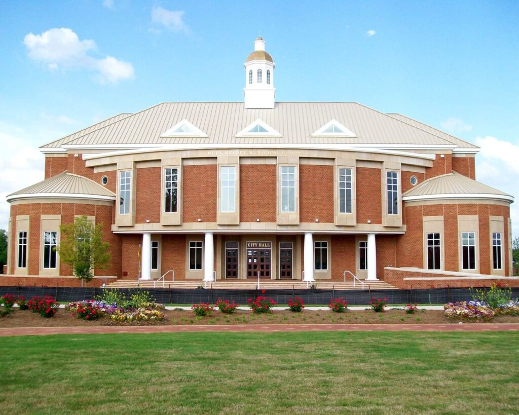 Stockbridge City Hall in Georgia, a red brick municipal building with columns and manicured lawn