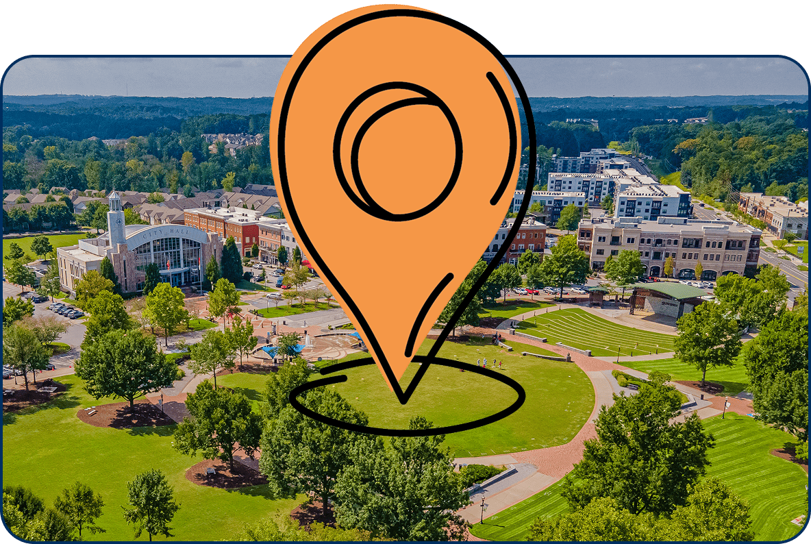 Large location pin icon over an aerial view of Suwanee Town Center with City Hall, green space, and nearby buildings