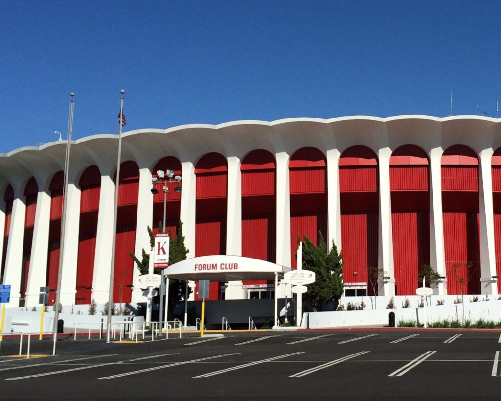 Exterior view of The Forum arena in Inglewood, California with red columns and modern architectural design