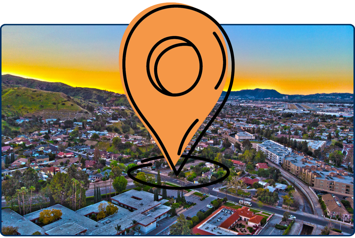 Aerial view of Inglewood California townscape at sunset with residential areas, roads, and hills under colorful sky