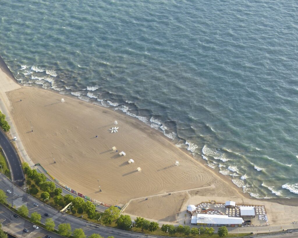 Chicago Oak Street Beach aerial view with sandy shoreline waves from Lake Michigan and nearby road cityscape Illinois