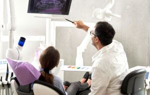 Dentist explaining dental X-ray results to patient in modern dental office