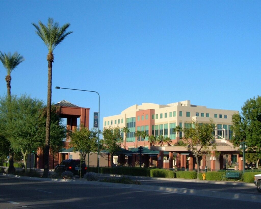 Downtown Chandler Arizona streetscape with palm trees, modern low-rise buildings, roadway and desert city urban development
