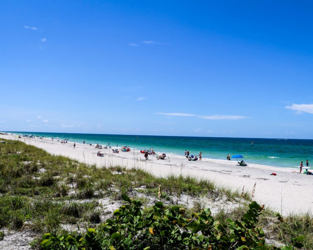 Englewood Beach Florida with white sand shoreline, turquoise water and people relaxing along the coast