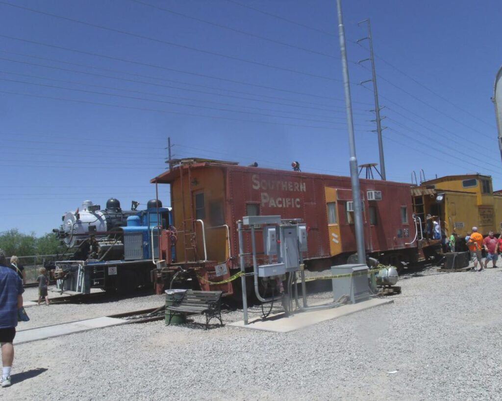 Historic trains and railcars at Chandler Arizona Railroad Park with Southern Pacific caboose, locomotive exhibits and visitors