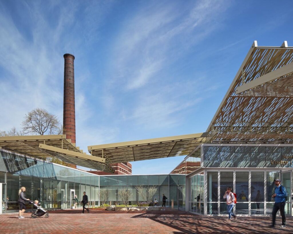 Lincoln Park Zoo Visitor Center Chicago modern glass building architecture with people walking and blue sky