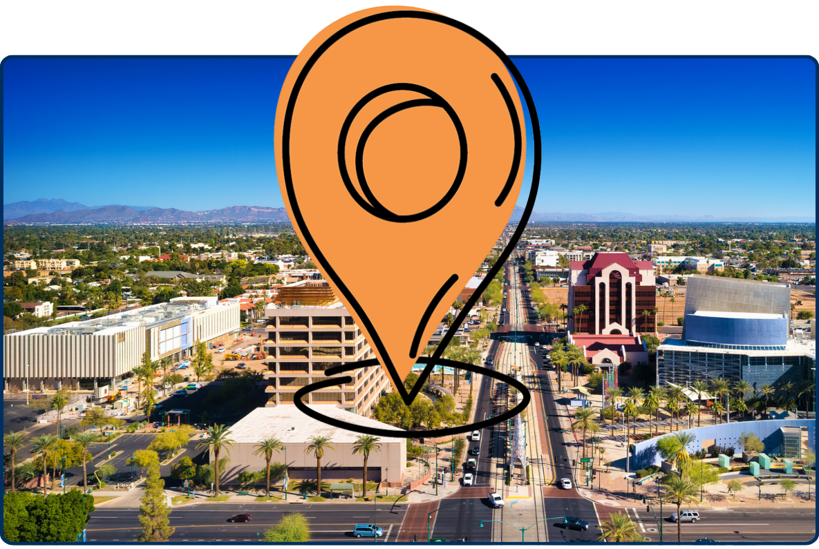 Aerial view of downtown Mesa Arizona with light rail, city buildings, palm-lined streets and distant mountains