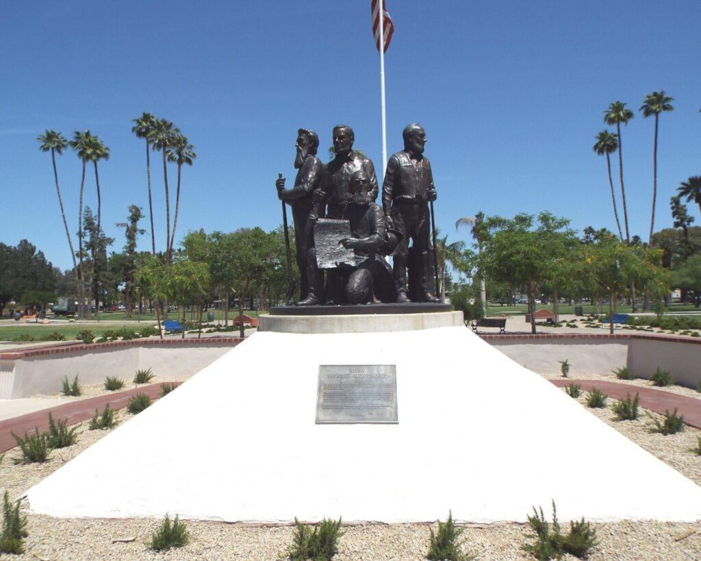 Mesa Pioneer Monument in Pioneer Park Mesa Arizona with bronze pioneer statues, palm trees and landscaped plaza