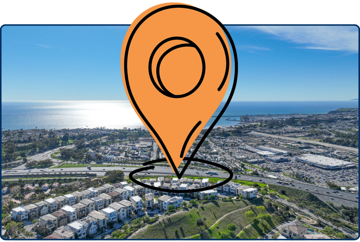 Aerial view of San Juan Capistrano California coastline with residential area highway and Pacific Ocean under clear sky