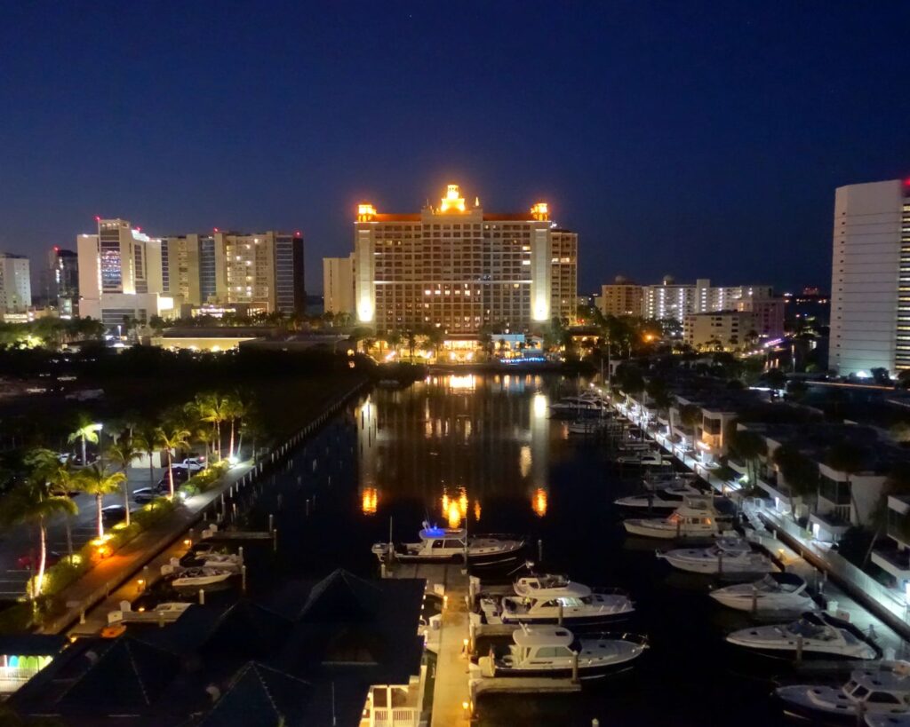 Sarasota Florida marina at night with yachts boats waterfront skyline city lights reflection harbor USA coastal nightlife scene