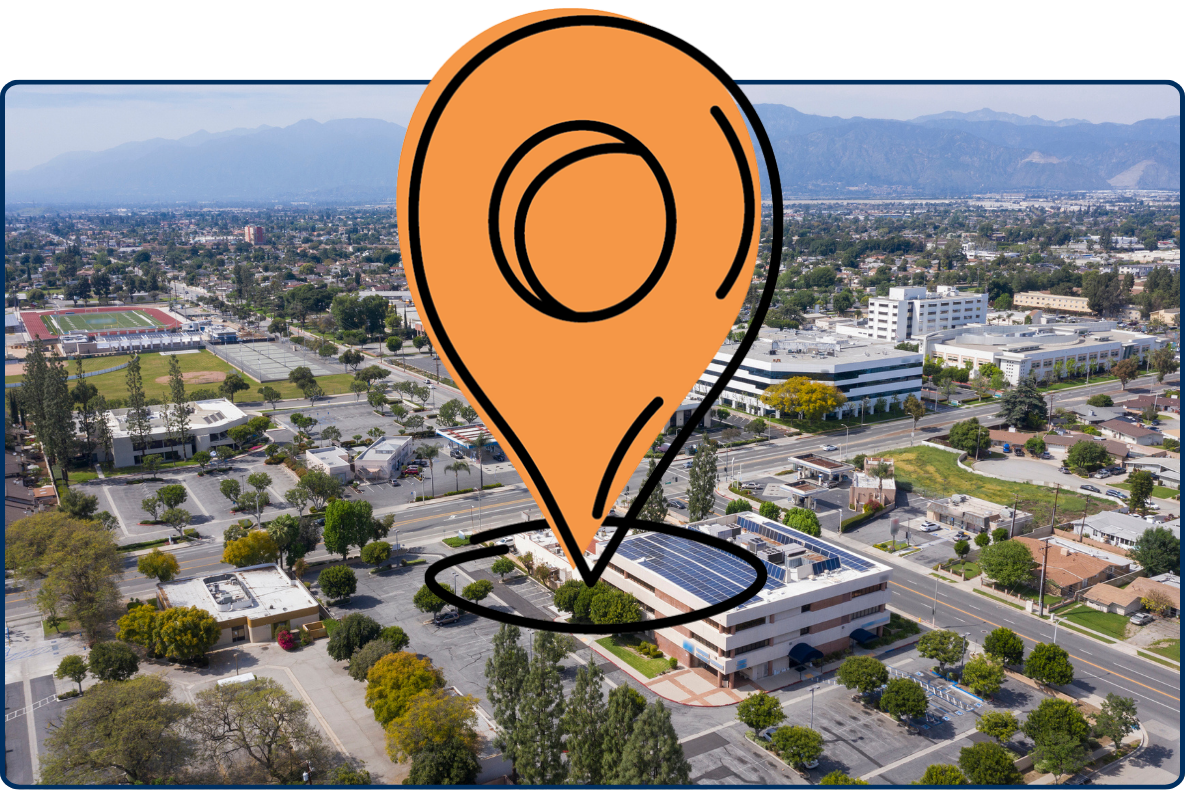 Aerial view of West Covina California city center with streets buildings offices and mountains in background