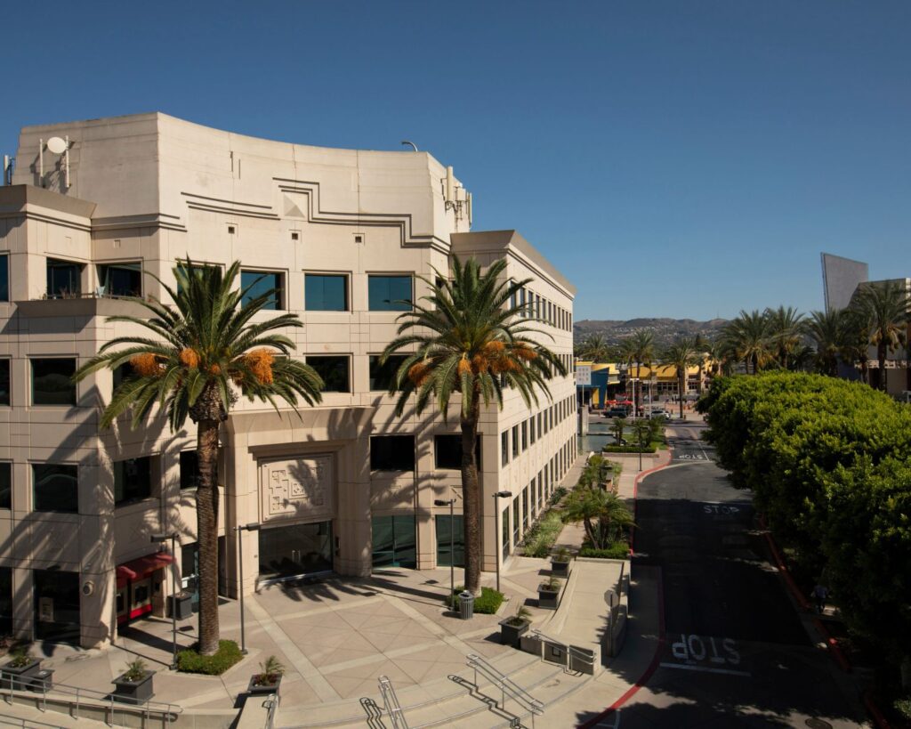 Modern office building with palm trees in downtown West Covina California under clear blue sky daytime view
