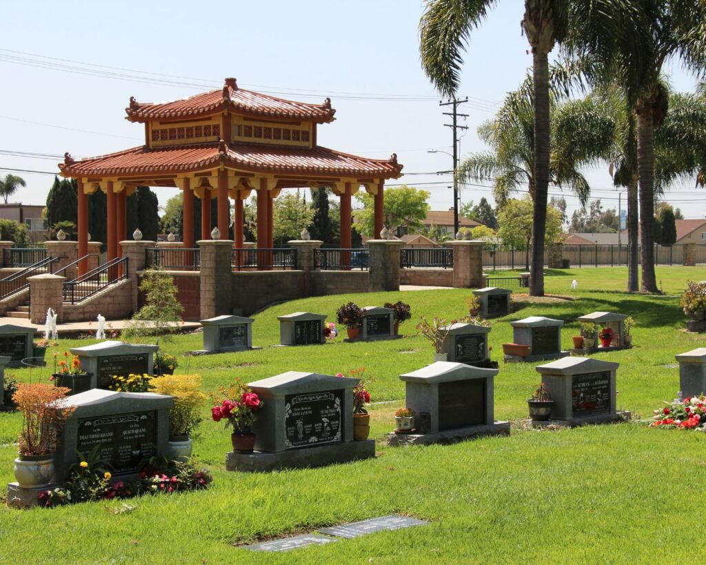 Westminster Memorial Park garden with pagoda structure graves landscaped lawn and palm trees in California