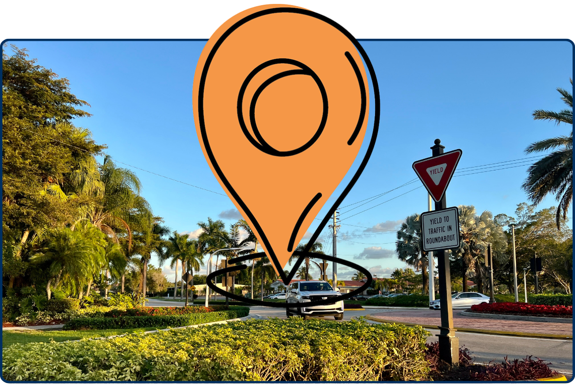 Roundabout at Bonaventure Boulevard and Blatt Boulevard Weston Florida with cars palm trees and traffic sign