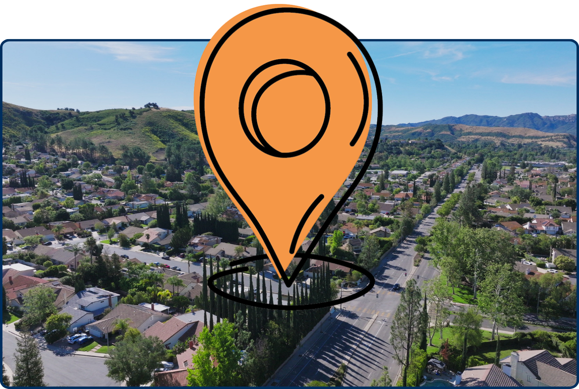 Aerial view of a suburban neighborhood in Agoura Hills, California, with residential streets, houses, trees, and rolling green hills in the background.