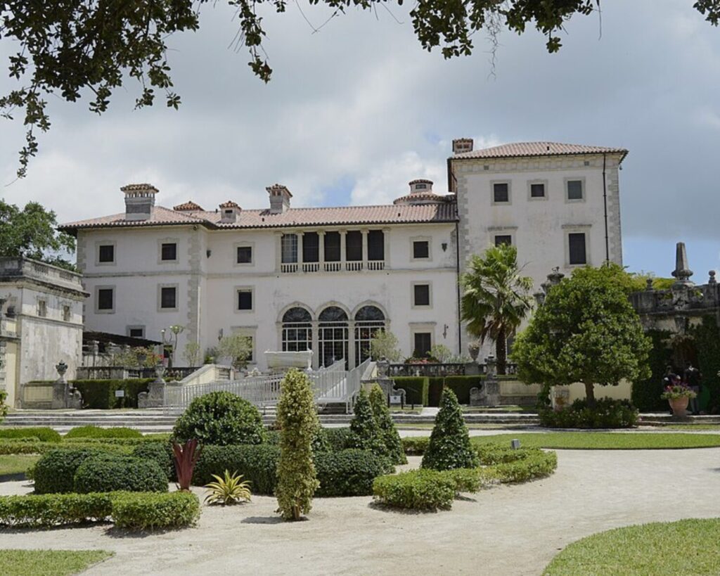 Vizcaya Museum and Gardens exterior with manicured lawns, historic architecture, and cloudy sky in Miami.