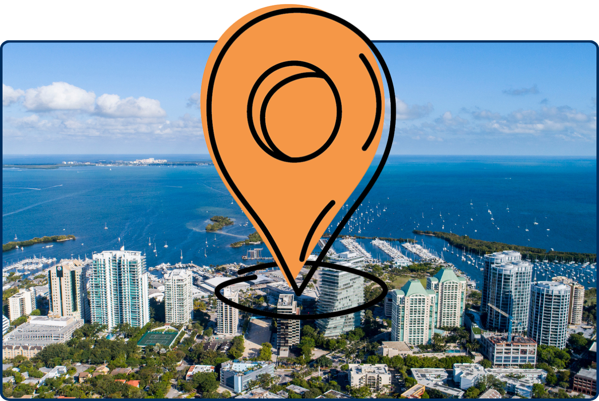 Aerial view of Coconut Grove, Miami with high-rise buildings, marina, blue bay, and distant islands.