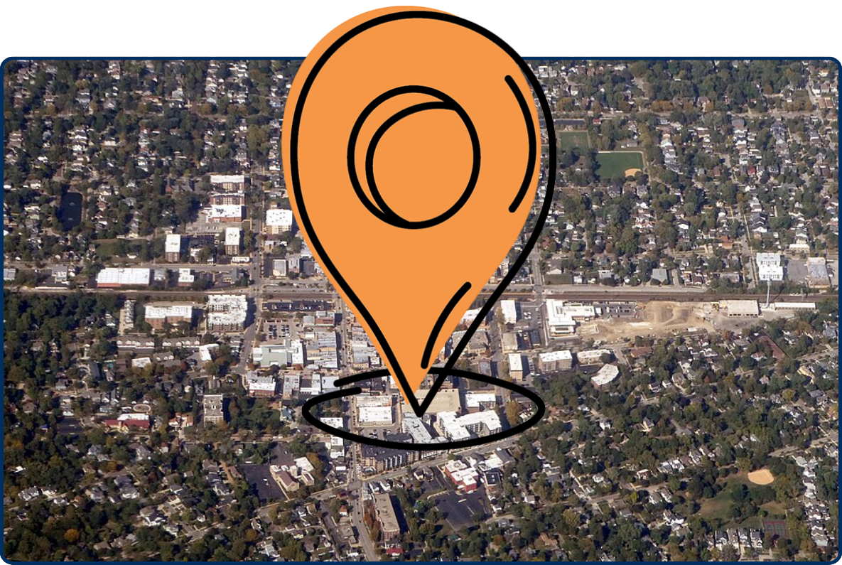 Aerial view of downtown Downers Grove, Illinois, showing dense residential neighborhoods, tree-lined streets, and a central commercial district intersected by major roads.