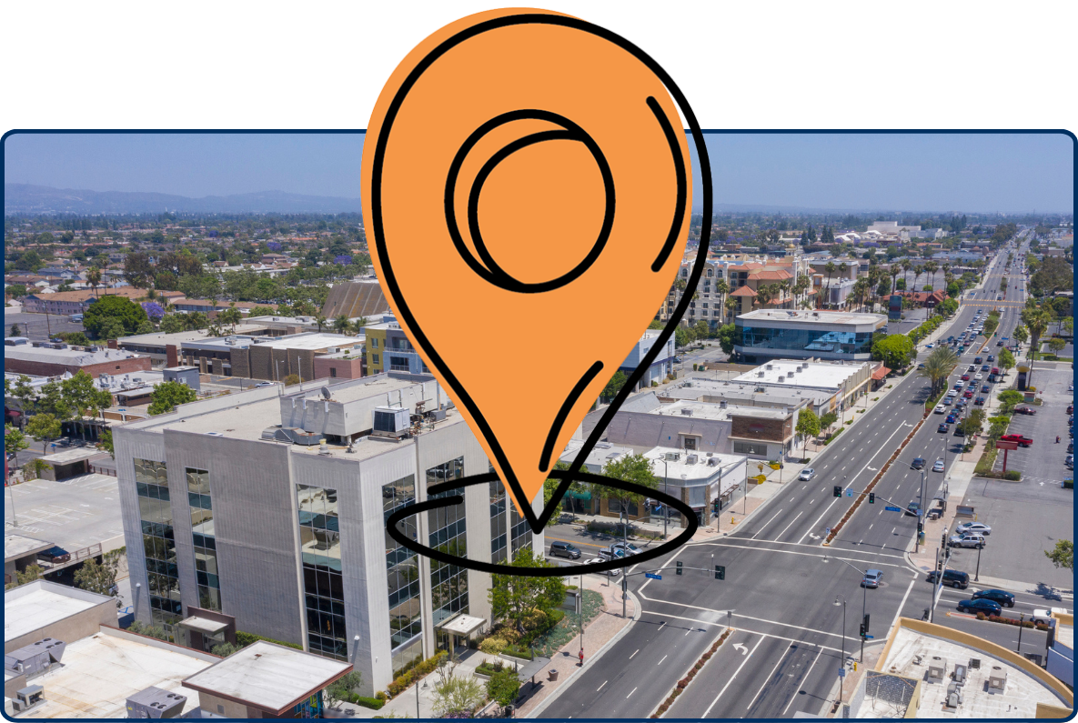 Aerial view of Downey, California with city streets, buildings, and traffic under a clear sky.