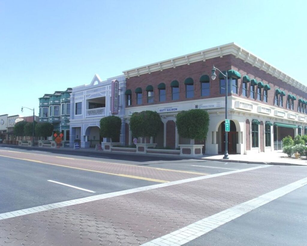 Historic buildings along a street in Gilbert Heritage District with storefronts and clear blue sky.