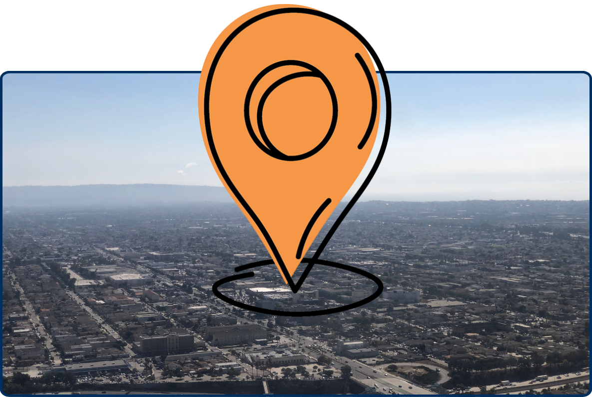 Aerial view over Hawthorne, Los Angeles County with dense urban layout and distant hills under a hazy sky.