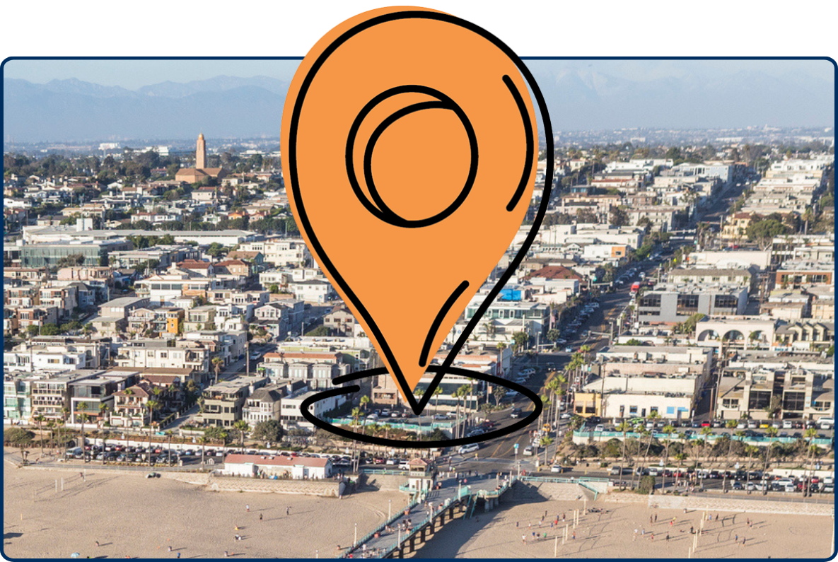 Aerial view of Manhattan Beach, California, showing the ocean pier extending into the Pacific Ocean with sandy beaches and a dense coastal neighborhood in the background.