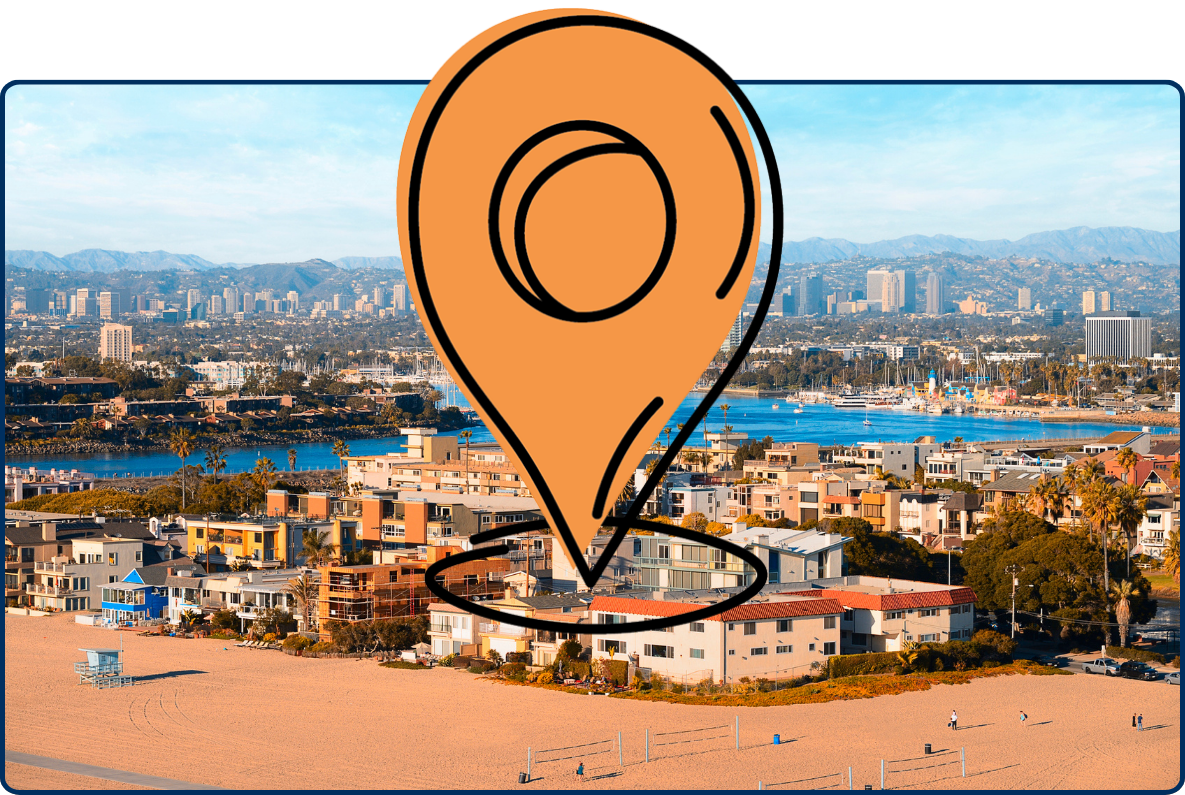 Panoramic view of Marina del Rey, California, featuring beachfront homes, a marina filled with boats, city buildings, and distant mountains under a bright blue sky.