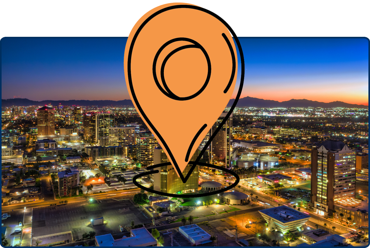 Aerial view of Midtown Phoenix, Arizona at sunset, featuring a sprawling urban skyline with high-rise buildings, palm-lined neighborhoods, and distant mountain ranges beneath a vibrant orange and pink evening sky.