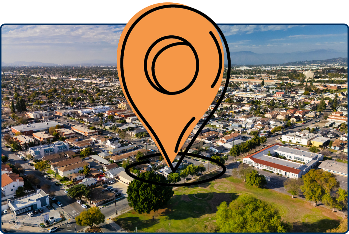 Aerial view of Norwalk, California neighborhood with homes, streets, and distant mountains.