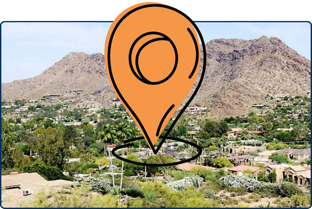 Panoramic view of Paradise Valley, Arizona, with desert homes and green landscaping set against rocky mountain terrain under a clear sky.