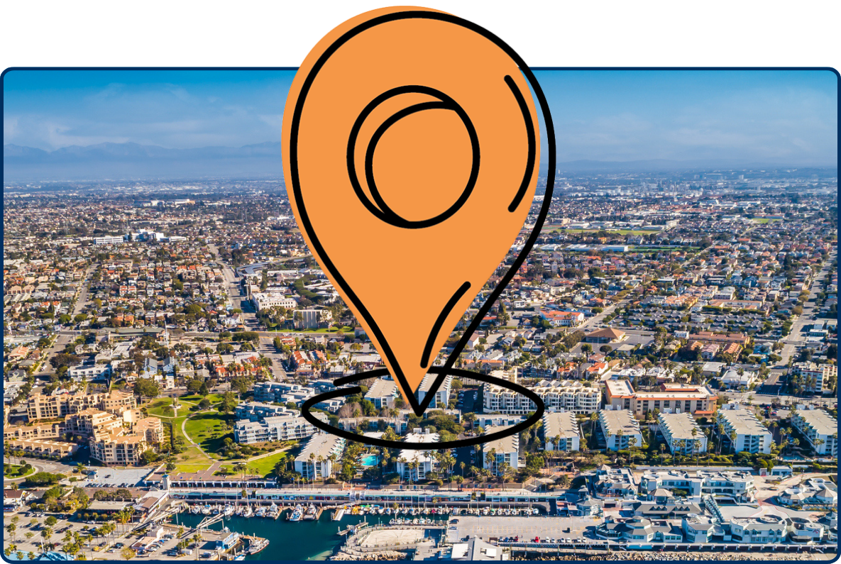 Aerial view of Redondo Beach coastline with pier, harbor, and dense cityscape along the Pacific Ocean.