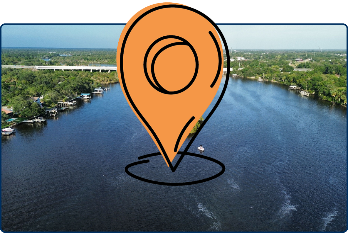 Drone view of the Alafia River in Riverview, Florida, featuring a small tree-covered island, surrounding waterways, and a bridge in the distance.