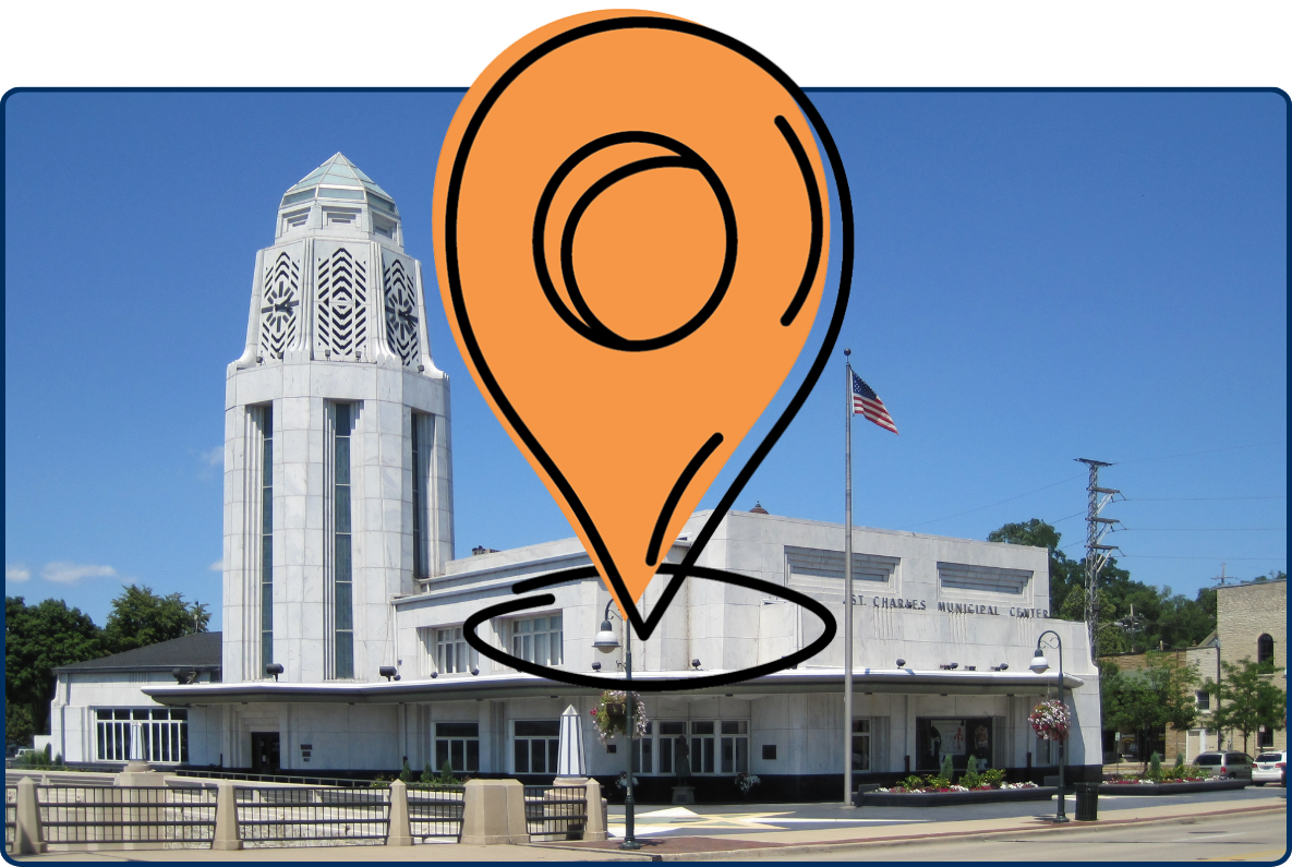 Art Deco-style St. Charles Municipal Building with tall white tower and American flag under a clear blue sky.