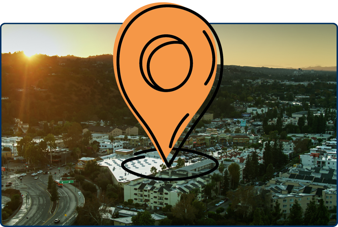 Aerial view of Ventura Boulevard in Studio City at sunset with hills and urban buildings.