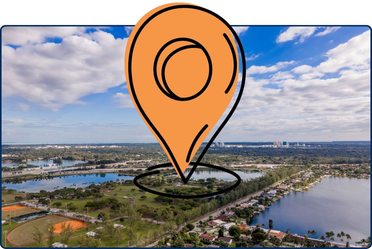 Aerial view of Tropical Park in Miami featuring lakes, green spaces, sports fields, and a wide cloudy sky stretching over the city landscape.