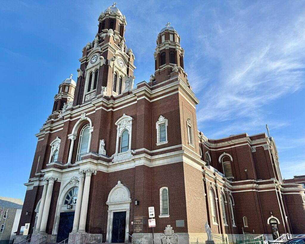 St. Hyacinth Basilica in Chicago with twin towers, brick architecture, and clear blue sky.