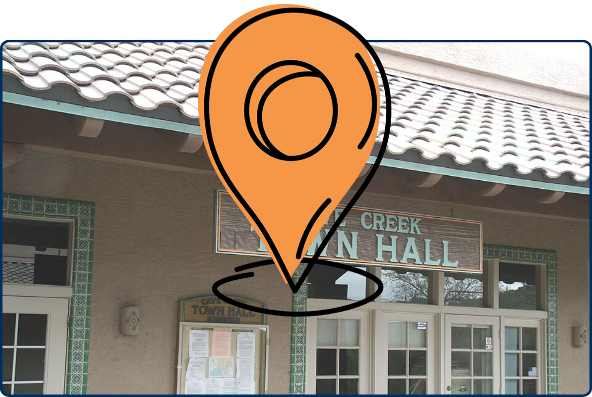 Cave Creek Town Hall entrance with tiled roof, wooden sign, glass doors, and bulletin board.
