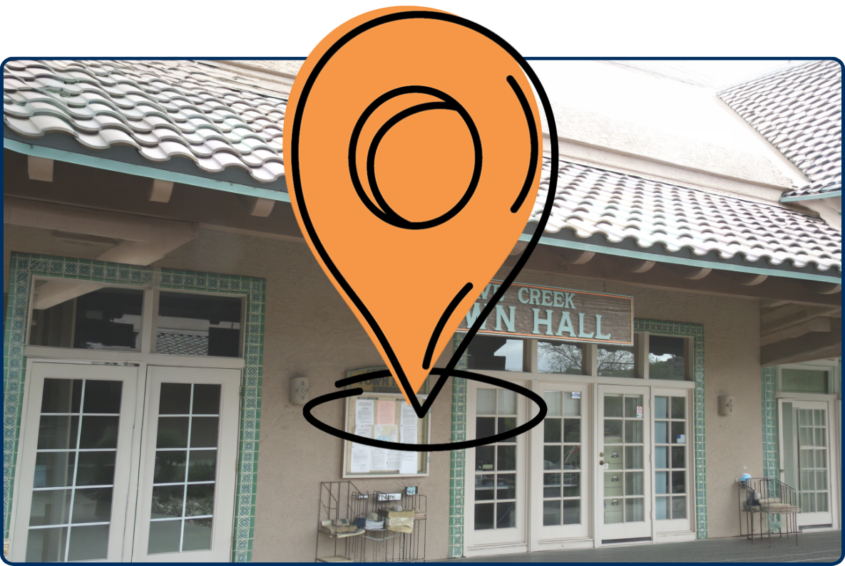 Cave Creek Town Hall entrance with tiled roof, wooden sign, glass doors, and bulletin board.
