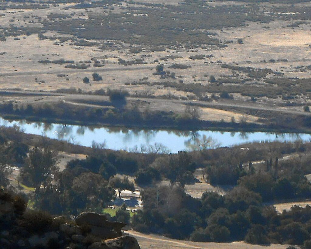 Aerial view of Chatsworth Nature Preserve with dry fields, water, rocks, and surrounding trees.