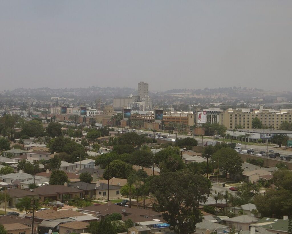 Citadel Outlet Mall area in Commerce, California with nearby homes, freeway, and hazy city skyline.