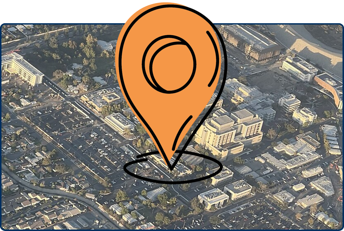 Aerial view of City of Hope campus with hospital buildings, parking lots, and surrounding neighborhoods.