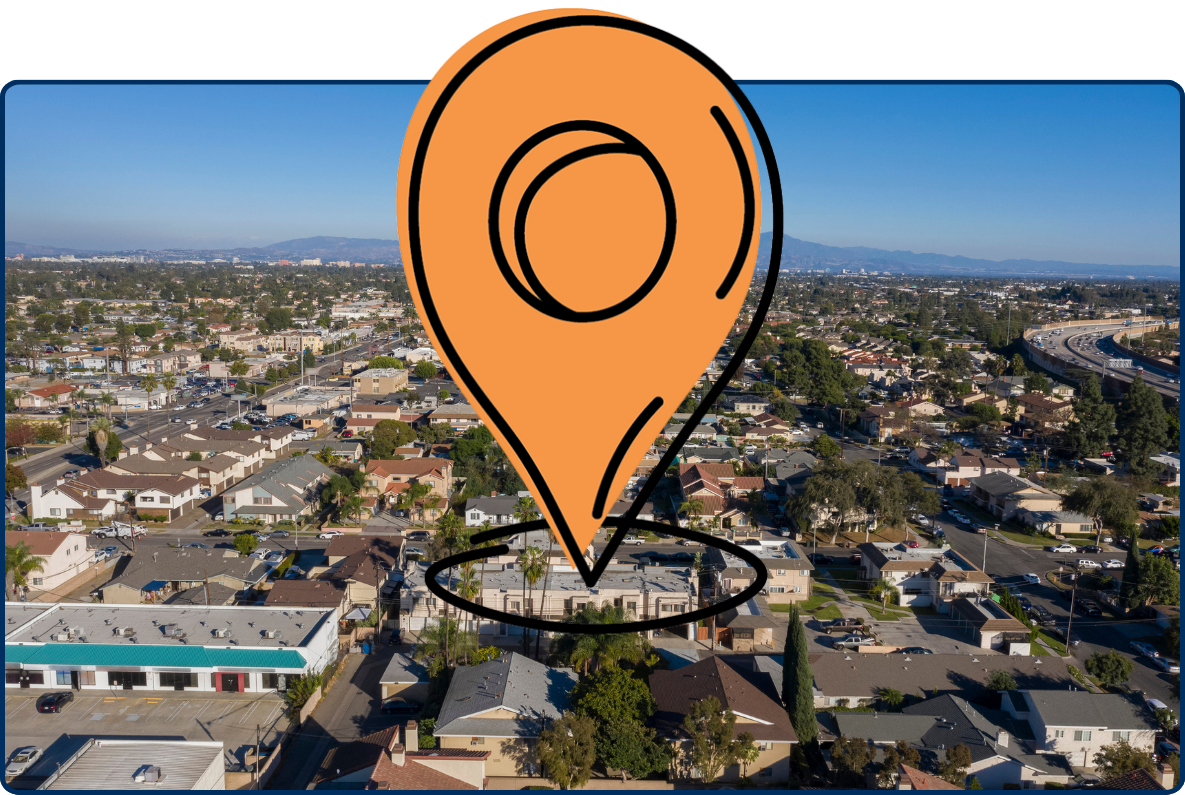 Aerial view of Garden Grove, California with suburban homes, roads, freeway, and distant mountains.
